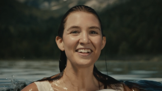 Shauna smiling in a lake in season 3, episode 3 of Yellowjackets hallucination scene