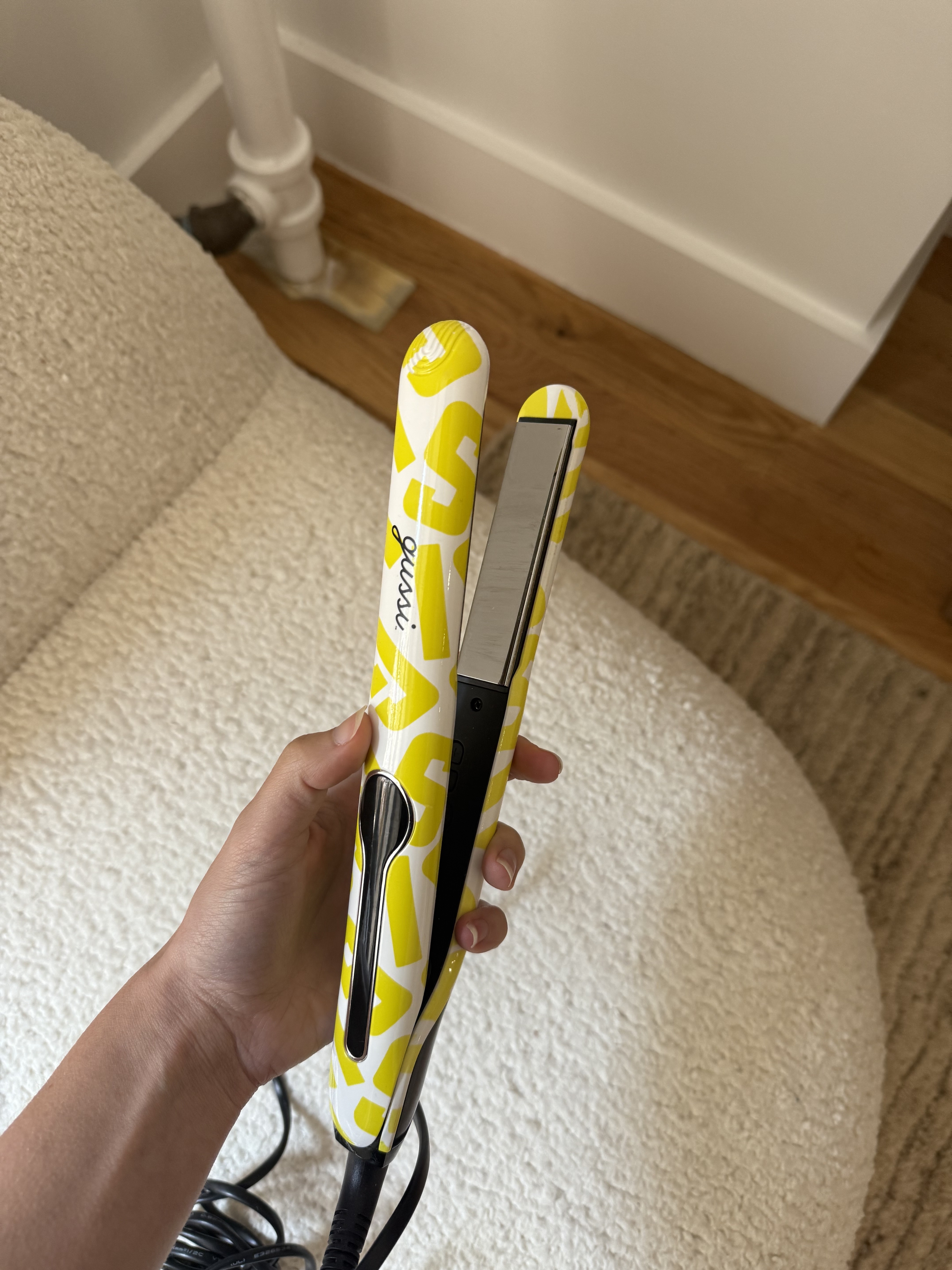Jamie Schneider holding the Gussi Haircare Mane Squeeze Flat Iron Hair Straightener.