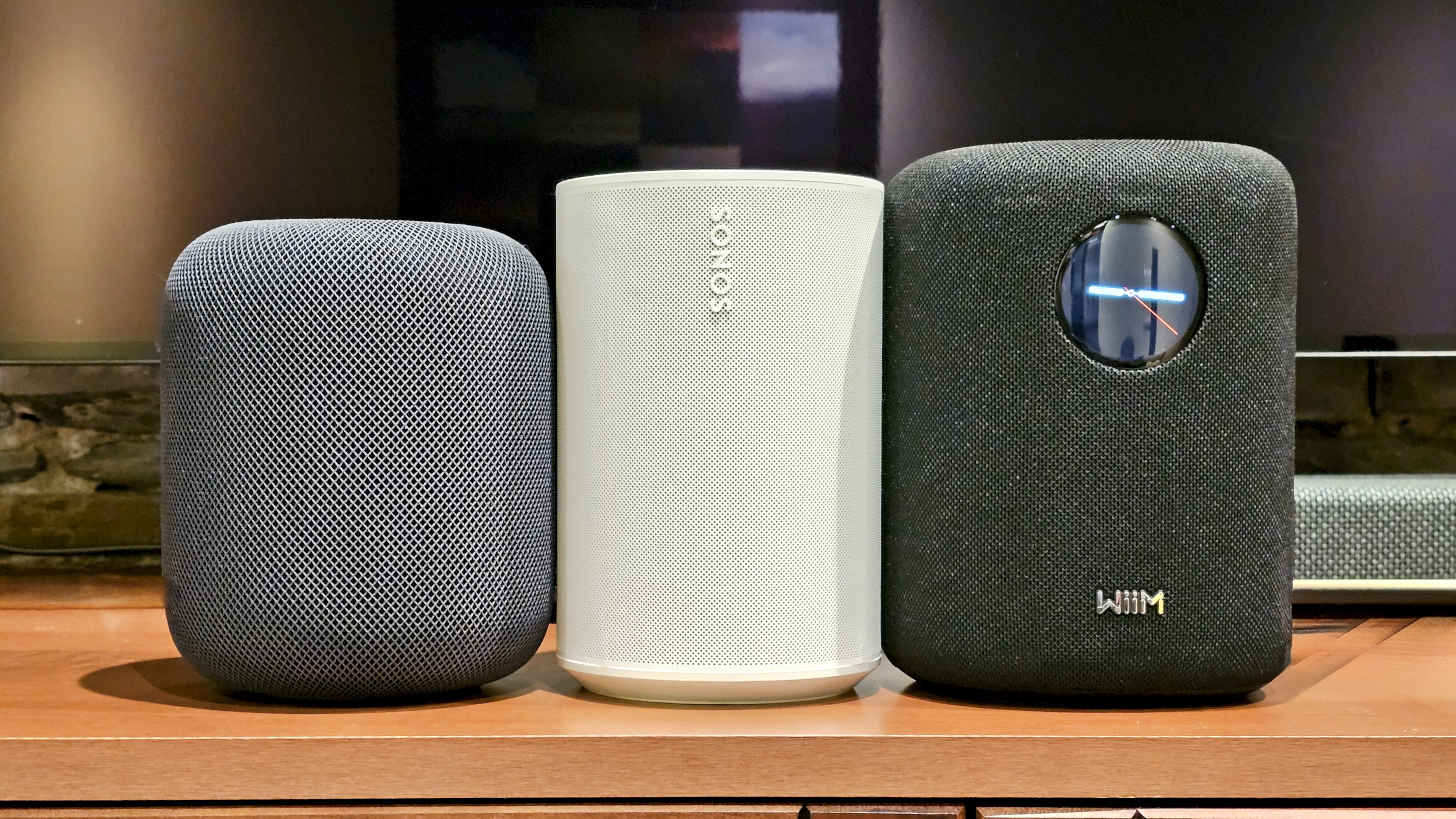 The WiiM Sound, in a home, on a varnished wooden table, showing the illuminated front panel