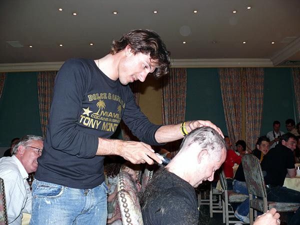 Fabian Cancellara helping to shave Mechanic Kenneth's head.