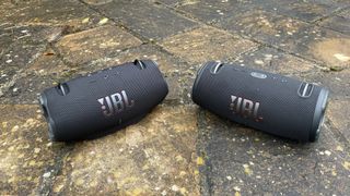 JBL Xtreme 4 and Xtreme 3 next to each other outside on the ground