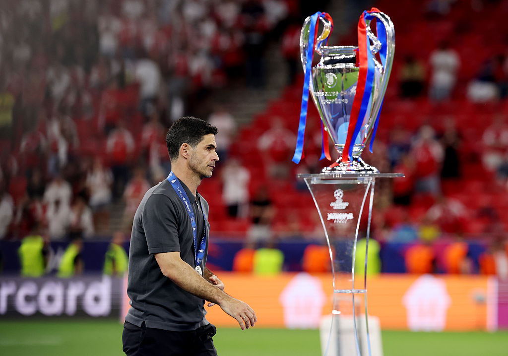 Arsenal manager Mikel Arteta walks past the Champions League trophy