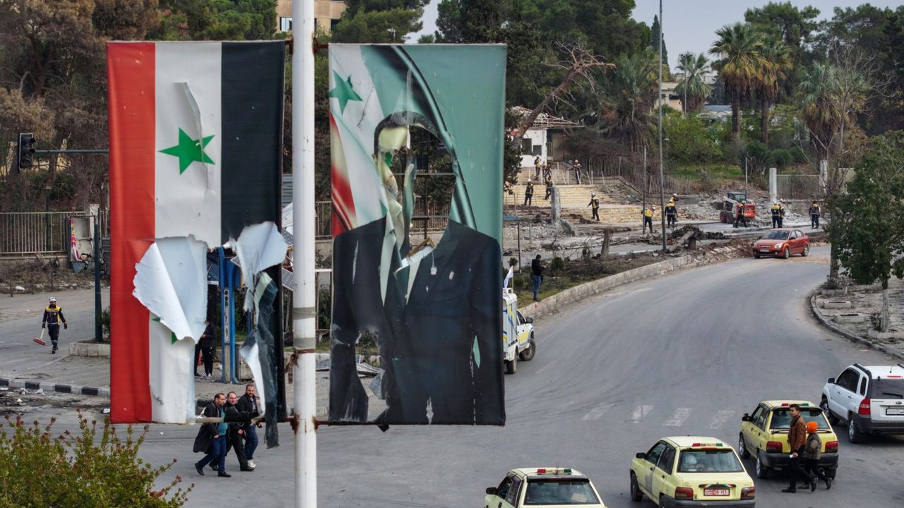 A banner depicting ousted Syrian leader Bashar al-Assad is seen damaged in Aleppo.