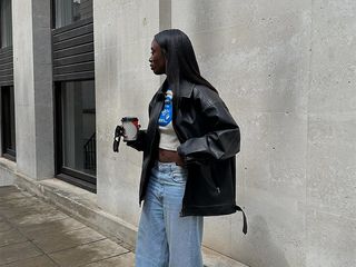 Influencer wears jeans, t-shirt, and black leather jacket.