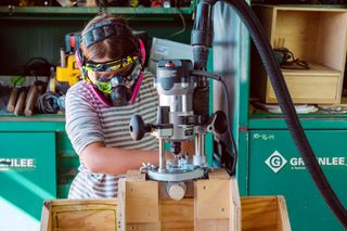 A young girl working on a wood-cutting machine at the Lumber Club Marfa