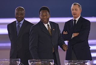 Football legends Cameroon's Roger Milla, Brazilian Pele and Dutch Johan Cruyff are seen during the final draw of the Fifa World Cup 2006 in Leipzig 09 December 2005. World Cup holders Brazil and the other 31 nations competing in next year's finals learnt their first-round opponents when the draw was made in a star-studded ceremony. AFP PHOTO FRANCK FIFE