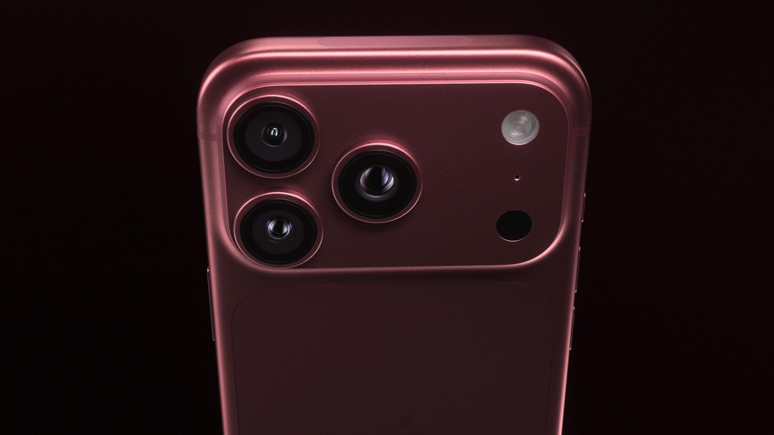 The back of a burgundy iPhone 18 Pro on a black background.