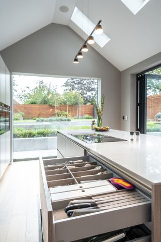 this picture window in a modern kitchen adds a connection to the outdoor space