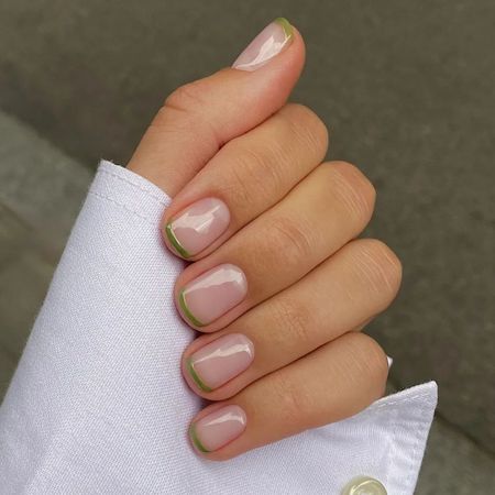 A clear manicure with a green French tip