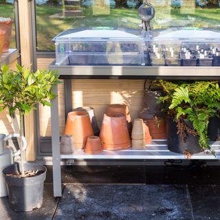 Potting shelf with plants and pots