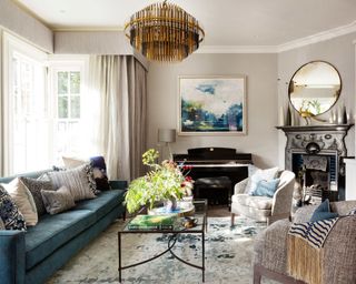 living room furniture arranging mistakes, living room with focal pendant, rug, blue couch, fireplace, artwork, pelmet, drapes, armchairs, piano