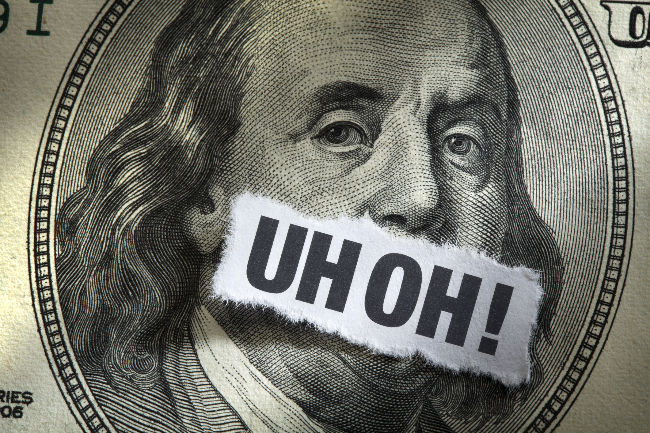 Hundred dollar bill with text "Uh OH!" over Franklin's mouth.