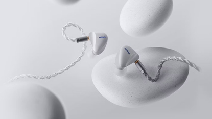 Activo Scoop earbuds on a light great background with what looks like grey pebbles