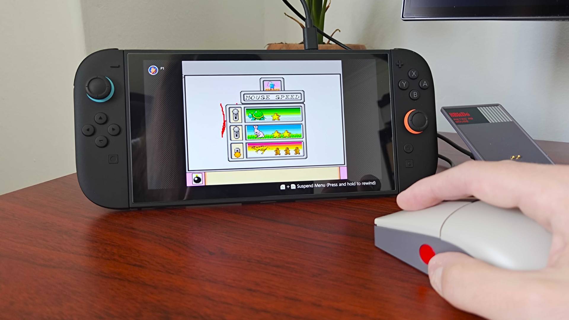 Hand using 8Bitdo Retro R8 mouse to adjust Mario Paint settings on Switch 2.