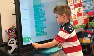 Students practice coding skills on the ActivPanel.