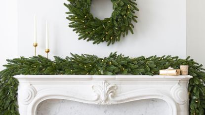 pine garland above marble fireplace