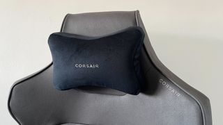 A close up shot of the top of a Corsair Gaming Chair in a plain room.