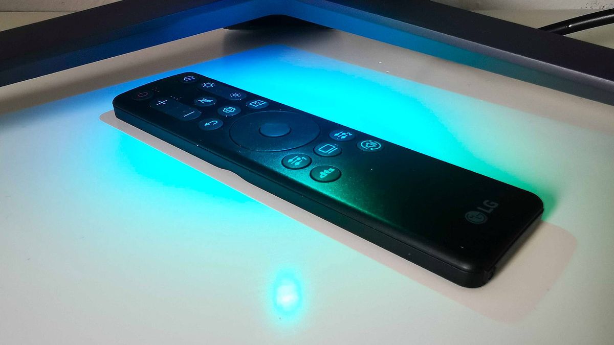 LG UltraGear 45GR95QE remote on white desk with blue RGB lighting