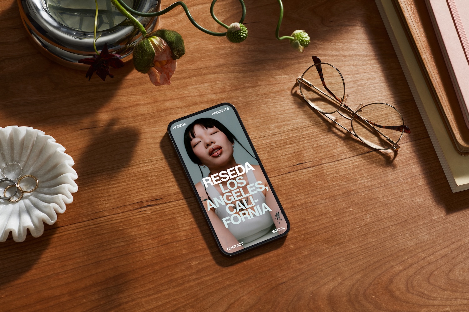 A phone on a desk featuring a website made on Squarespace.