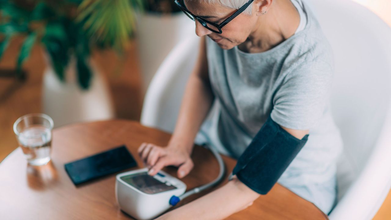 How to lower your blood pressure quickly: Image shows woman taking blood pressure at home