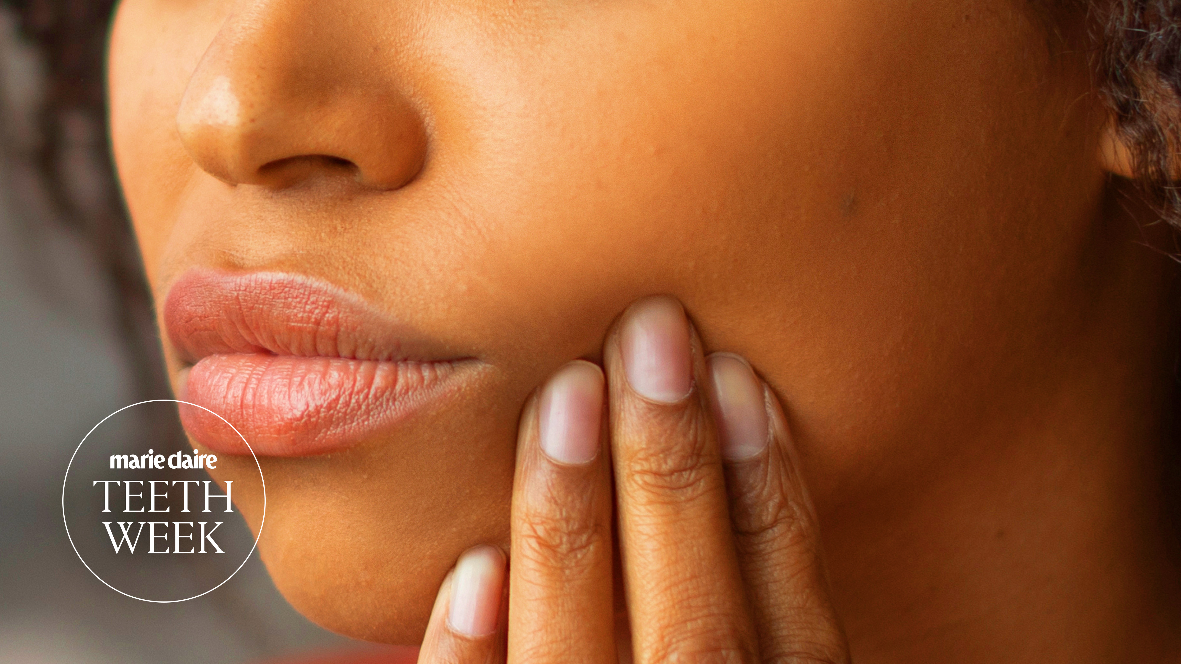 a close up of a woman's jaw and lips, and she is holding up a hand to her chin as if she is in pain