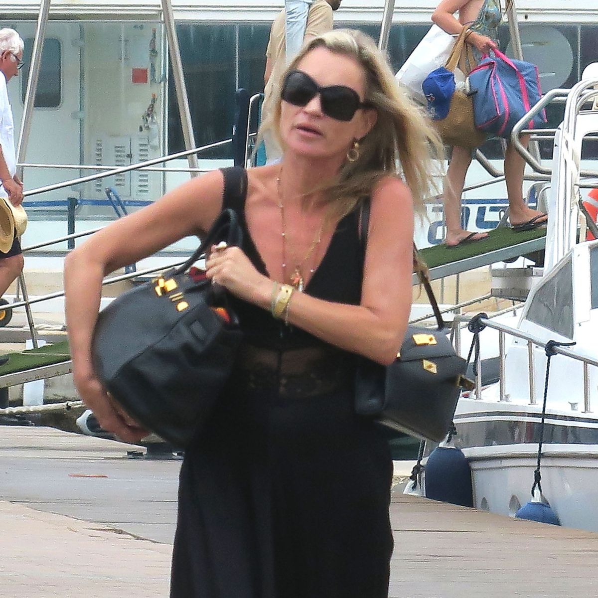 An image of Kate Moss wearing an Herm&egrave;s Birkin and Herm&egrave;s Kelly with ballet flats whilst on holiday. 