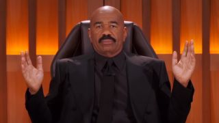 Steve Harvey throwing hands up behind bench in Judge Steve Harvey