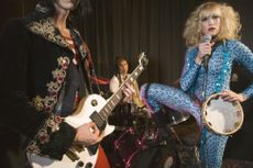 Female rock stars perform in over-the-top outfits.