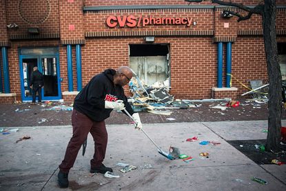 Residents clean outside of a Baltimore CVS.