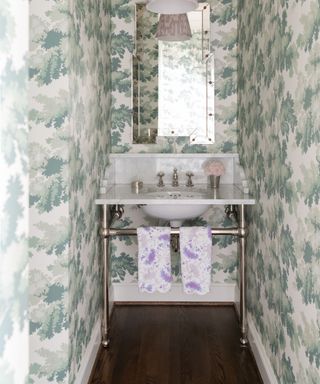 small powder room with white basin and green patterned wallcovering