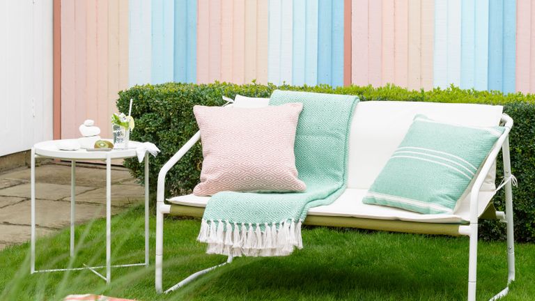 pastel pink and blue fence with white bench