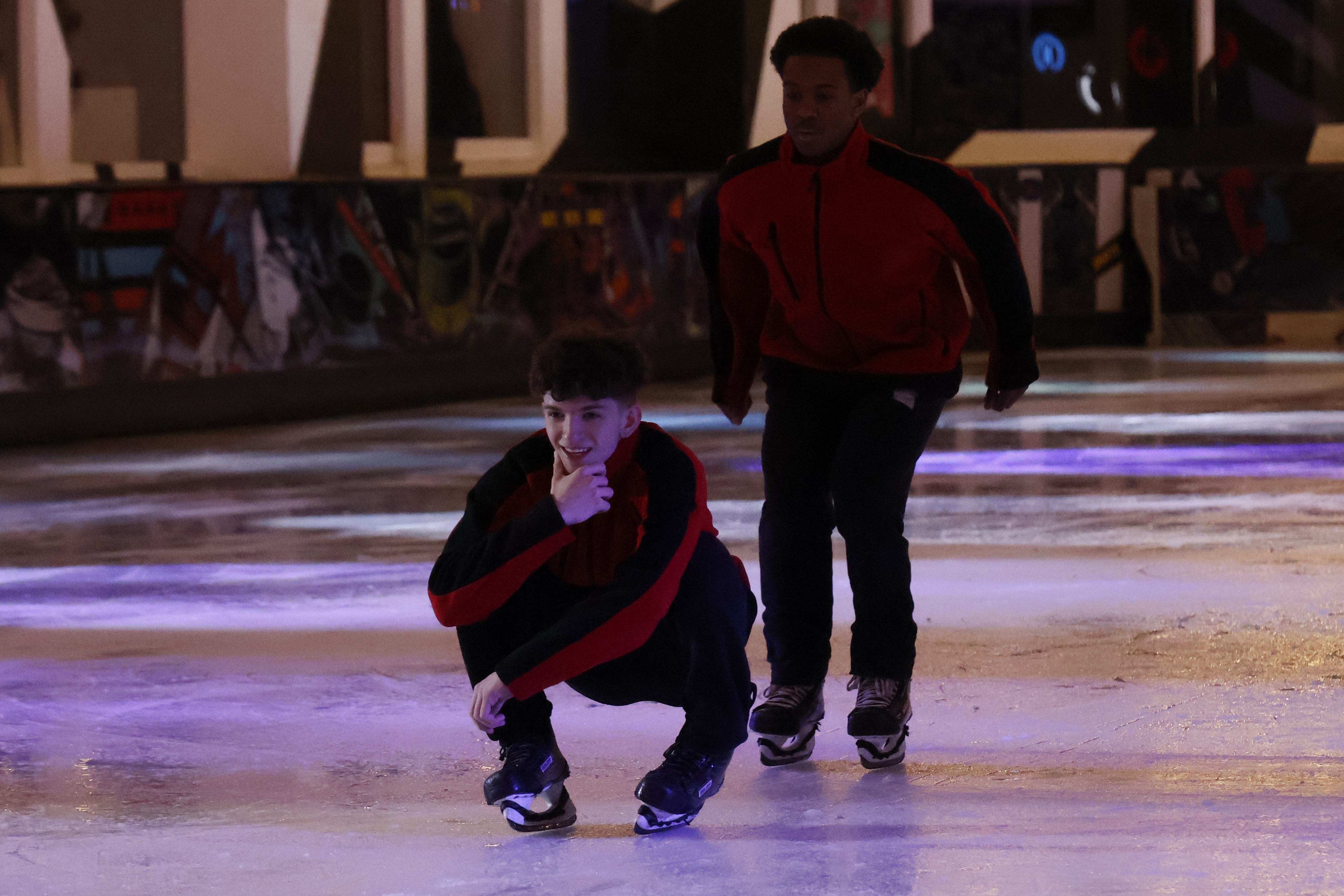 Two ice skaters performing at an ice rink