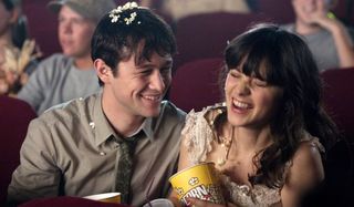 Joseph Gordon-Levitt and Zooey Deschanel laugh over popcorn at the movies in (500) Days of Summer.