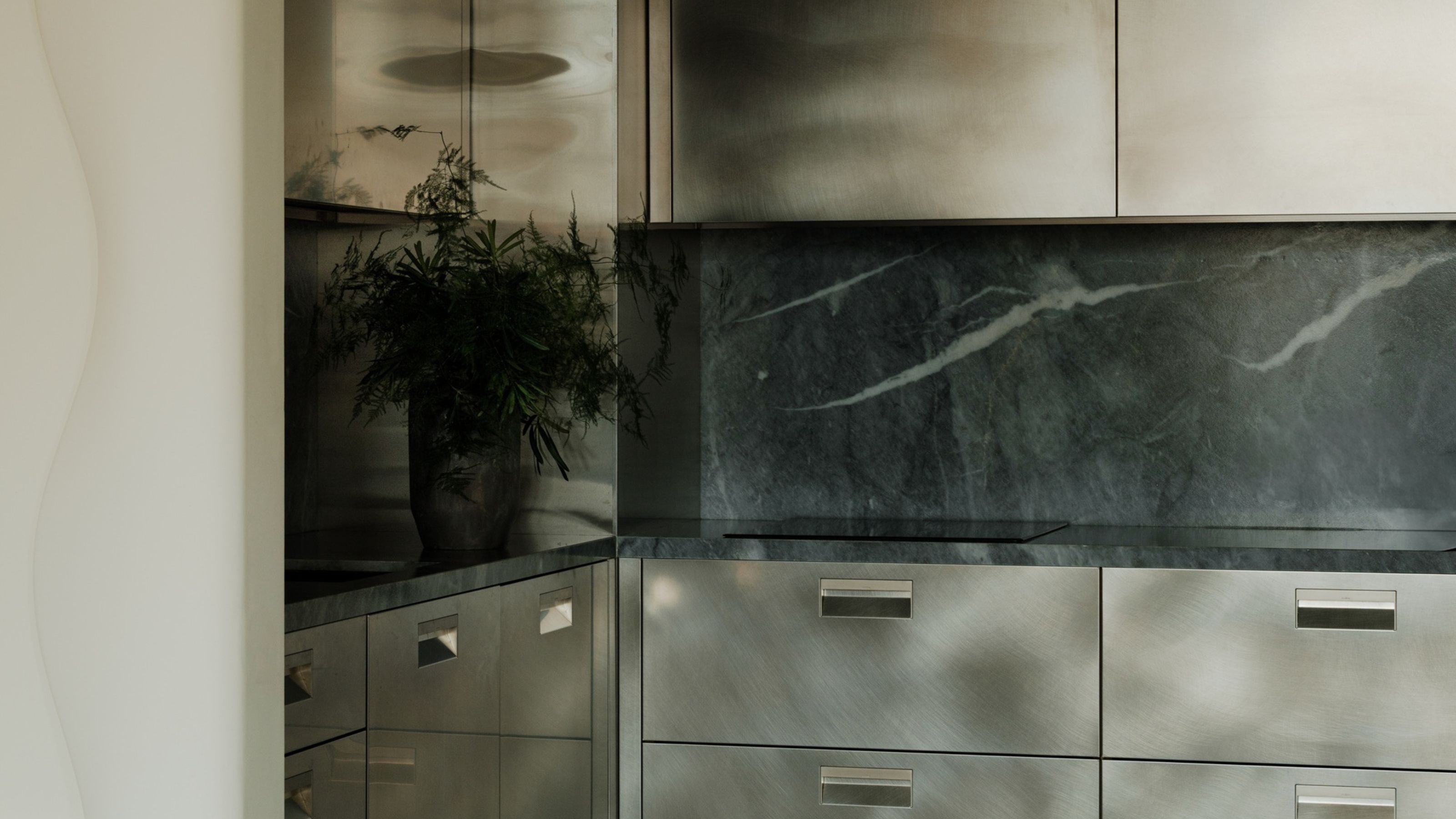 a dark gray stainless steel kitchen with a marble backsplash and checkerboard floors