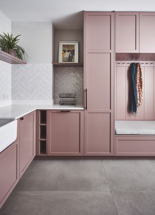 utility room design with pink cupboards and coat hooks