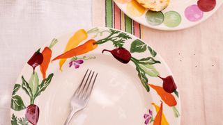 Cream ceramic plate with vegetable illustrations around the edge