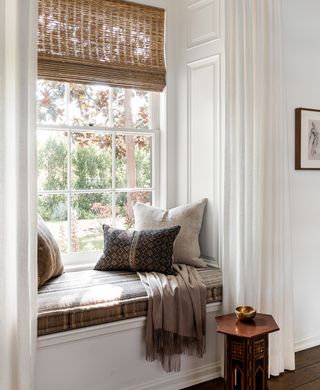 calming window seat with beige cushions in a white living room