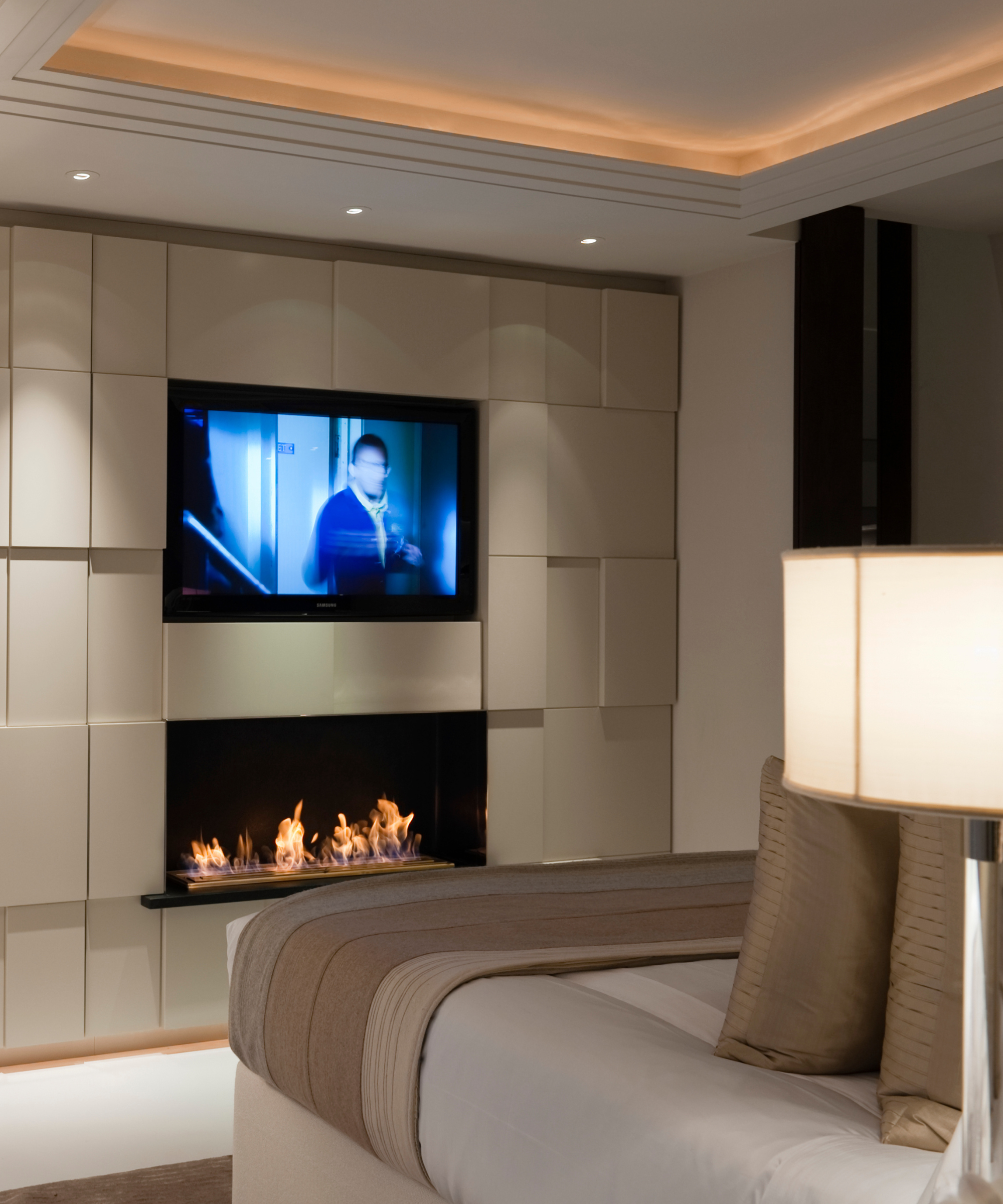 A wall-mounted TV in the bedroom of a city apartment
