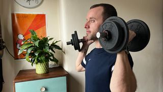 James Frew performing a dumbbell workout at home