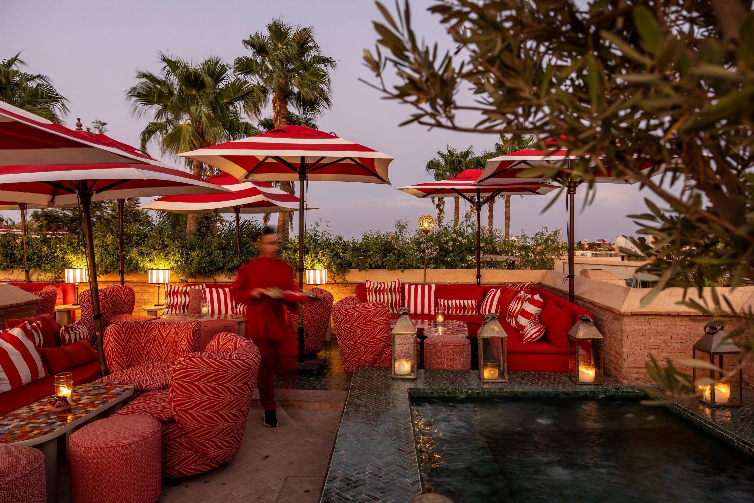 El Fenn hotel rooftop with red sofas and striped umbrellas