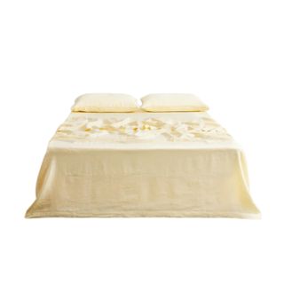 A butter yellow bed sheet with two matching pillowcases on top of it