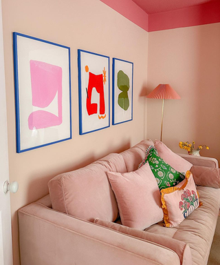 A pink themed living room with geometric wall art
