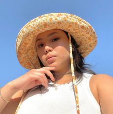 @marina_torres wearing a sun hat.