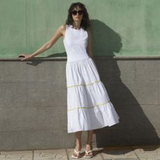 Woman wearing French Connection white tiered dress in street 