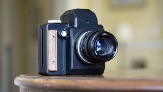 Nons SL660 instant camera on a mahogany table
