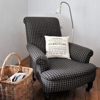 armchair with cushion and basket with floor lamp