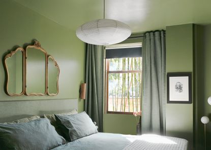 A small bedroom fully painted in green