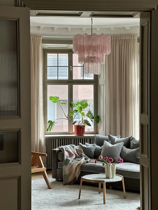 a living room with a pink glass chandelier