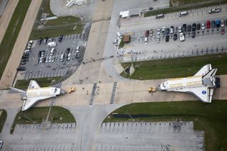 A unique glimpse of operations at NASA's Kennedy Space Center in Florida shows space shuttle Discovery, at right, approaching shuttle Endeavour outside Orbiter Processing Facility-3 (OPF-3). Discovery, which temporarily was being stored in the Vehicle Assembly Building (VAB), is switching places with Endeavour, which has been undergoing decommissioning in OPF-1.