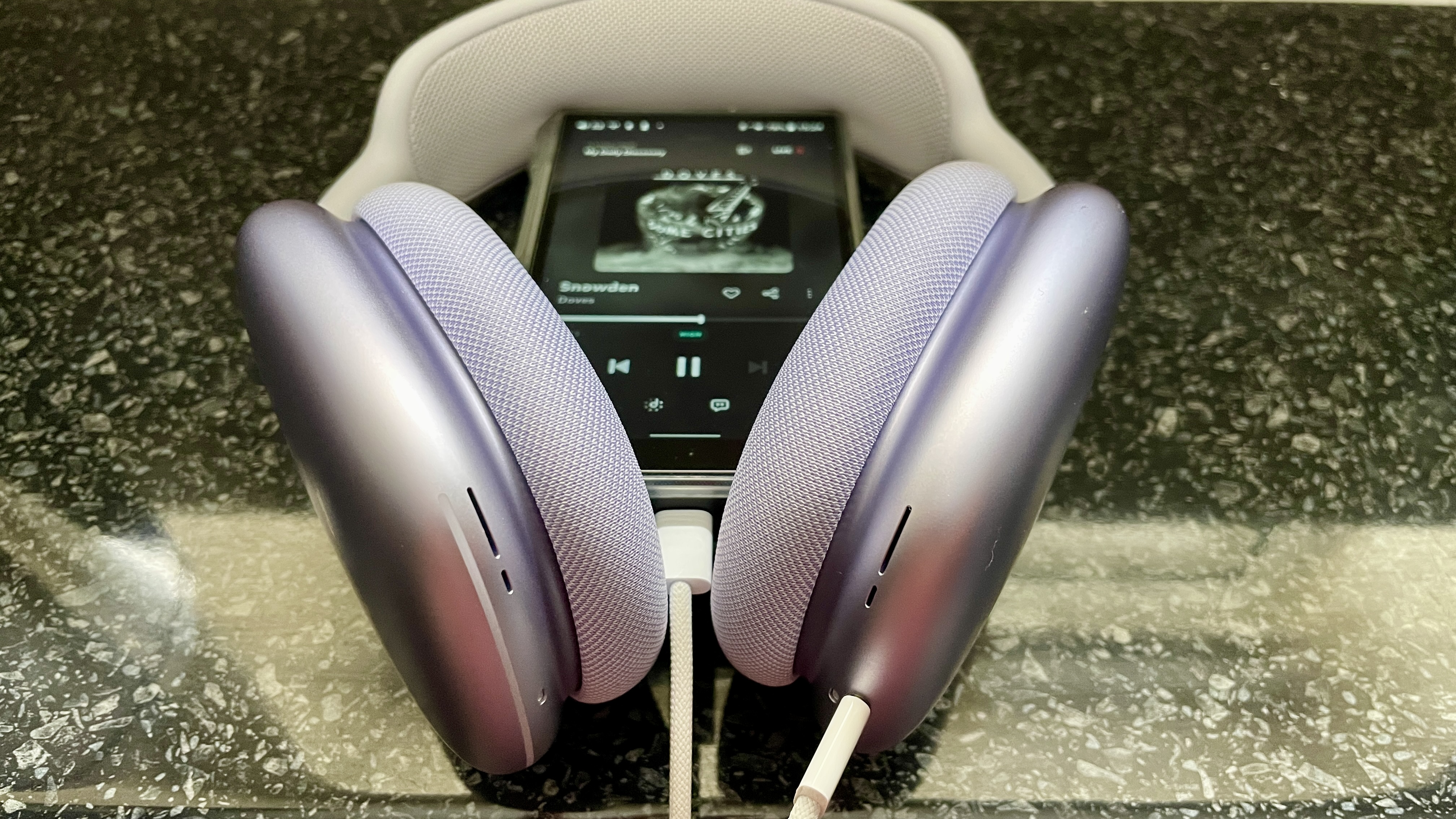 AirPods Max on a black table, with a FiiO player